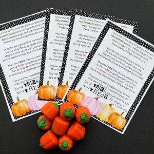 May include: Four rectangular cards with black and white polka dot borders featuring printed Halloween text and watercolor pumpkin illustrations, accompanied by a small pile of orange pumpkin-shaped candies with green stems.