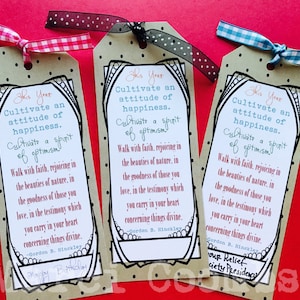 May include: Three brown paper tags with black polka dots and black borders. Each tag has a white background with black text that reads "This Year Cultivate an attitude of happiness. Cultivate a spirit of optimism. Walk with faith, rejoicing in the beauties of nature, in the goodness of those you love, in the testimony which you carry in your heart concerning things divine. - Gordon B. Hinckley". The first tag has the text "Happy Birthday" written in black ink below the quote. The second tag has a blank space below the quote. The third tag has the text "Your Relief Society Presidency" written in black ink below the quote.