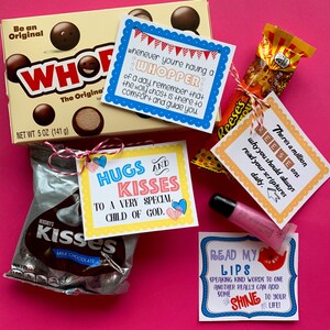 May include: A collection of small gift bags filled with candy and inspirational messages. The bags include Hershey's Kisses, Reese's Peanut Butter Cups, and a Whopper candy bar. The messages include "Hugs and Kisses to a Very Special Child of God", "There's a million reasons why you should always read your scriptures daily", "Whenever you're having a Whopper of a day, remember that the Holy Ghost is there to comfort and guide you", and "Read My Lips: Speaking kind words to one another really can add some shine to your life!"
