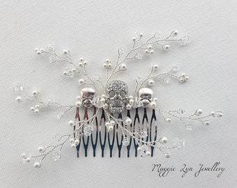 May include: Silver hair comb with three silver skull charms and white pearl beads. The comb is decorated with silver wire and crystal beads. The text "Maggie Lyn Jewellery" is visible in the bottom right corner of the image.