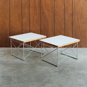 May include: Two square side tables with white tops and light wood edges. The tables have a chrome wire base. The tables are approximately 18 inches wide and 18 inches deep.