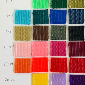 May include: A color chart with 22 different colored fabric swatches. The swatches are arranged in rows of three, with the numbers 1-3, 4-7, 8-11, 12-15, 16-19, and 20-22 written to the left of each row.