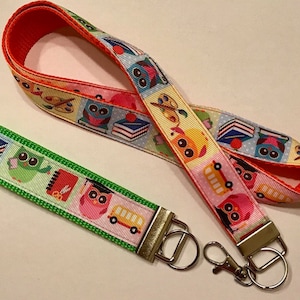 May include: A colorful lanyard with a green, red, and yellow owl design. The lanyard has a matching detachable key chain with a green, red, and yellow owl design.