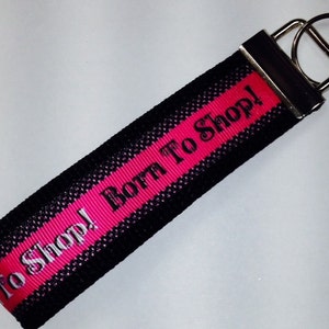 May include: Black and pink key chain with the text "To Shop! Both To Shop!" printed on it.