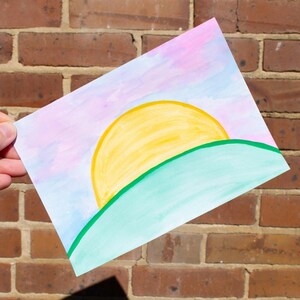 Hermosa tarjeta de felicitación pintada a mano con puesta de sol