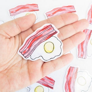 Pegatina de acuarela de desayuno con huevos y tocino