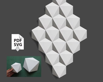May include: A white papercraft geometric wall sculpture made of 3D triangles. The sculpture is shaped like a diamond and is made up of 20 individual triangles. The sculpture is shown against a dark gray background. PDF and SVG files are available for download.