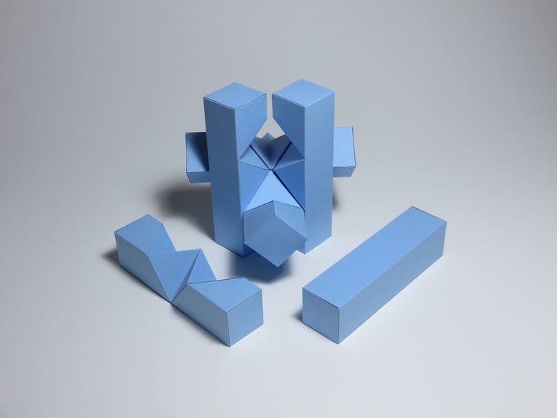 May include: A blue geometric puzzle made of paper. The puzzle is assembled into a star shape with four arms and a central piece. The puzzle is made of five pieces.