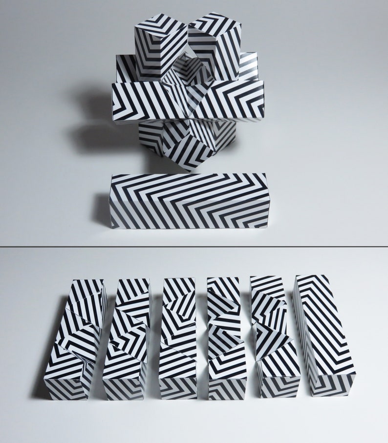 May include: A set of black and white striped geometric puzzle blocks. The blocks are arranged in a variety of configurations, including a tower and a line.