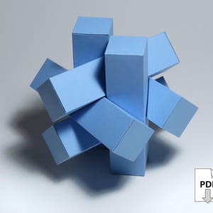 May include: A blue paper puzzle made of six connected cubes. The puzzle is in the shape of a star.