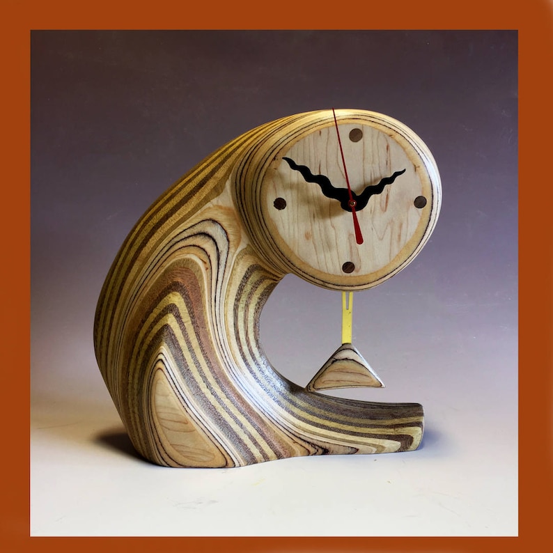May include: A wooden clock with a pendulum, the clock face is made of light wood with black hands and red hour hand, the clock is mounted on a curved piece of wood with a striped pattern in shades of brown, tan, and white.