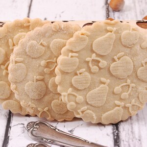 close up on round cookies presenting the results of embossing of a fruity jujice rolling pin.