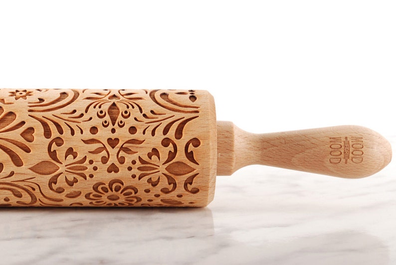 Wooden embossing rolling pin with moodforwood logo on the handle, embossing design is rosemaling, norwegian folk.