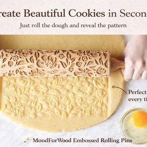 Puede incluir: Un rodillo de madera en relieve con un dise&ntilde;o floral rueda sobre la masa, creando un patr&oacute;n detallado. El texto dice "Create Beautiful Cookies in Seconds". Un peque&ntilde;o cuenco con una yema de huevo est&aacute; en la esquina.