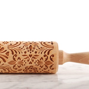 Wooden embossing rolling pin with moodforwood logo on the handle, embossing design is rosemaling, norwegian folk.