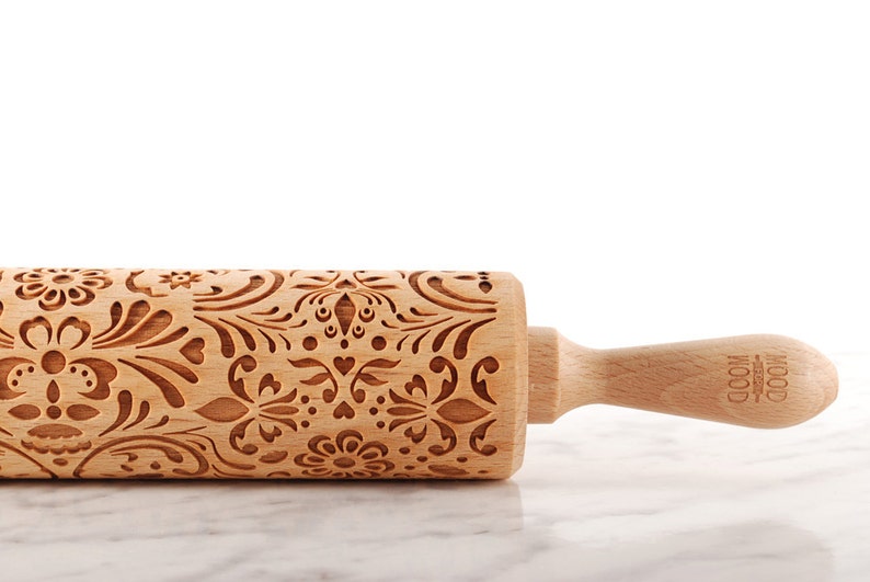 Wooden embossing rolling pin with moodforwood logo on the handle, embossing design is rosemaling, norwegian folk.