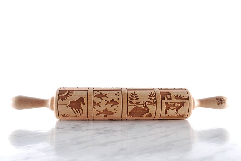 Wooden rolling pin laser engraed to make biscuits with different animal designs.