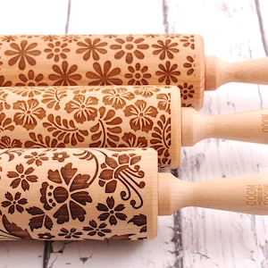 three wooden rolling pins laser engraved with 3 different floral patterns