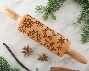 以下が含まれることがあります： 雪片と星のデザインが施された木製麺棒。麺棒には「WOOD & WOOD」と刻印されています。