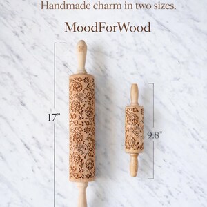 Puede incluir: Dos rodillos de madera con dise&ntilde;os florales, uno de 43 cm de largo y otro de 25 cm. Los rodillos tienen mangos de color claro y est&aacute;n etiquetados como "MoodForWood". La imagen tambi&eacute;n incluye el texto "Handmade charm in two sizes."