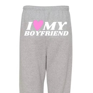 May include: Gray sweatpants with the text "I ♥ MY BOYFRIEND" printed on the back in white with a pink heart.