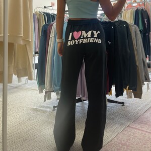 May include: Black sweatpants with the text "I &hearts; MY BOYFRIEND" printed on the back.