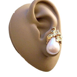 May include: Gold tone pear-shaped earrings with a white pearl and gold leaf accents.