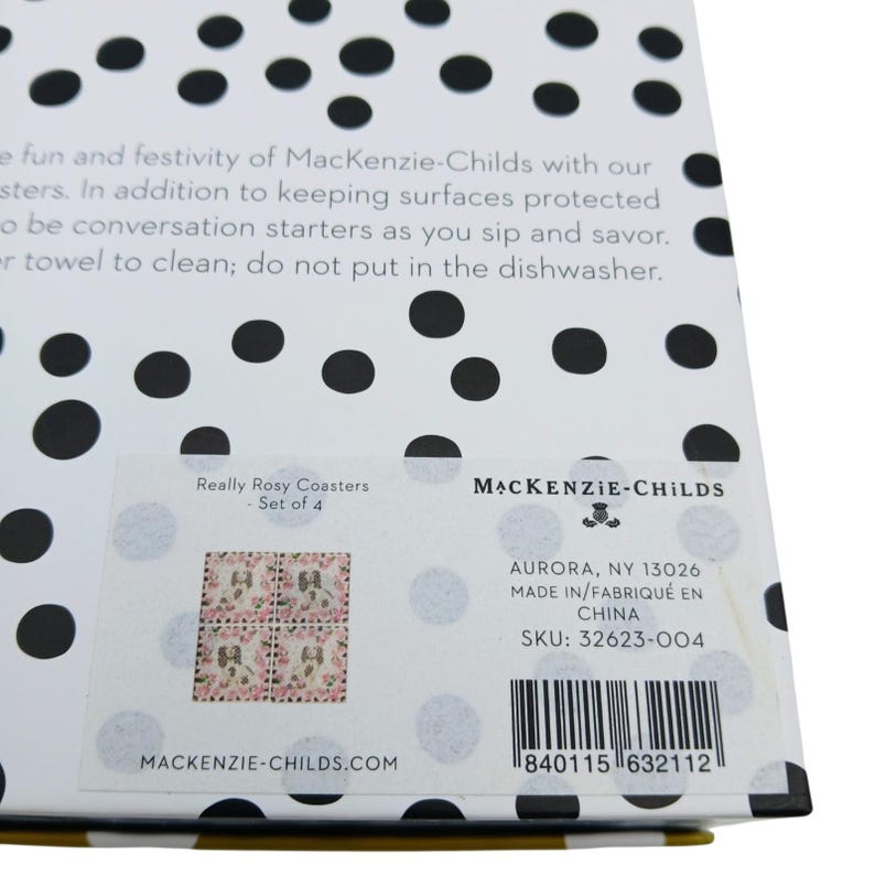 May include: A white product box featuring a black polka dot pattern. A label displays the text Really Rosy Coasters - Set of 4, MacKenzie-Childs, Aurora, NY 13026, Made in China, SKU: 32623-004, a barcode, and a small image of four floral coasters.