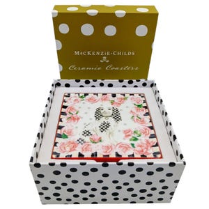 May include: A square ceramic coaster featuring a central illustration of a spaniel dog with black and white chequered ears, surrounded by pink roses and a black and white striped border, housed in a white box with black polka dots.