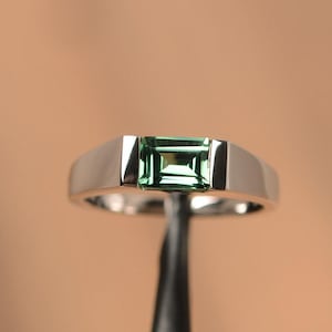 Anillo de compromiso con zafiro verde este-oeste y solitario de talla esmeralda en oro blanco macizo de 14 quilates.