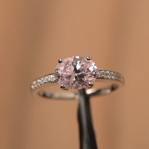 Anillo de compromiso de plata de ley con corte ovalado este-oeste y circonita cúbica rosa.