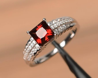 Anillo de granate rojo con piedra natal de enero y corte princesa en plata de ley.