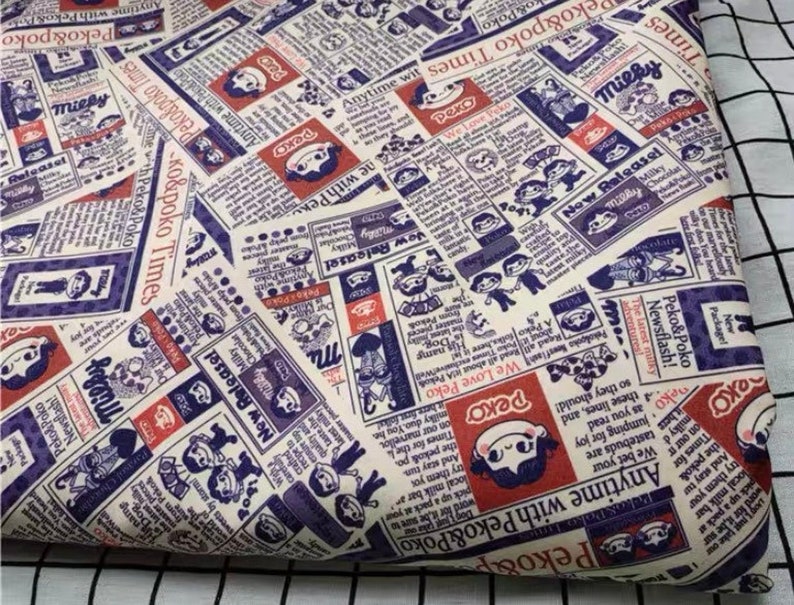 May include: A white fabric with a repeating pattern of newspaper clippings featuring illustrations of cartoon characters and the text "Peko&Poko Times".