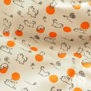 May include: White fabric with a repeating pattern of orange circles and black line drawings of cats playing with yarn.