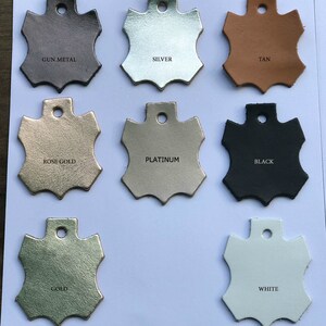 May include: Leather swatches in various colors, including gun metal, silver, tan, rose gold, platinum, black, gold, and white. Each swatch is shaped like a star with a hole in the center.