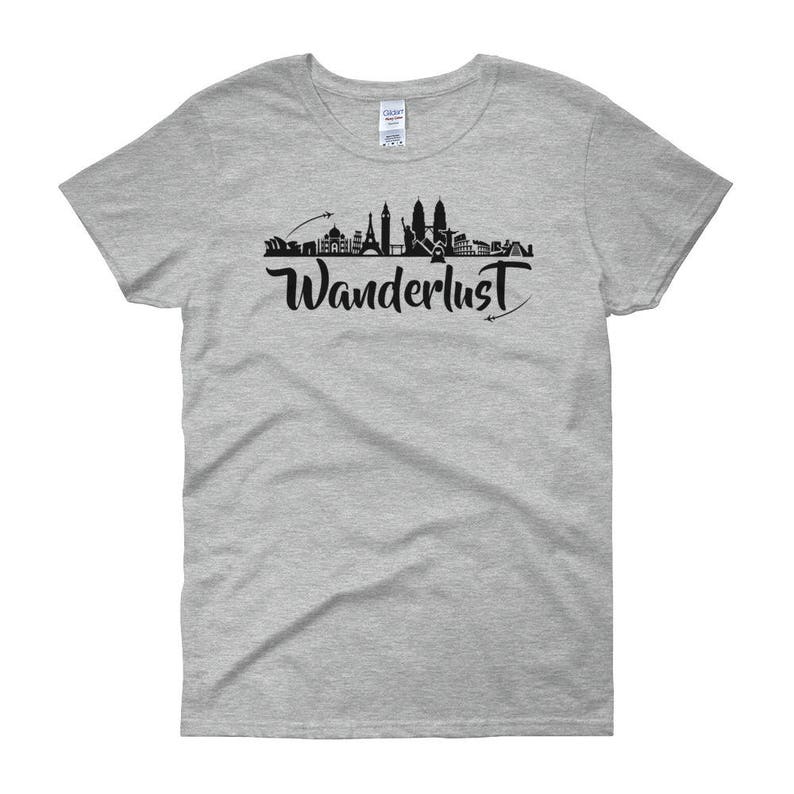 May include: A heather grey women's t-shirt with a black silhouette of a city skyline and the word "Wanderlust" in black script.
