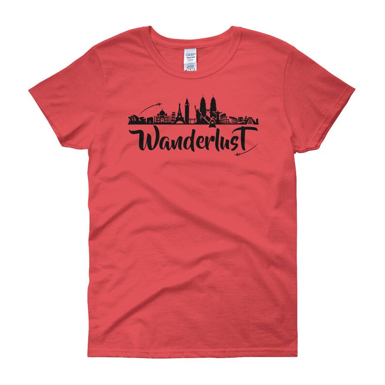 May include: Red women's t-shirt with a black silhouette of a city skyline and the word "Wanderlust" in black script.