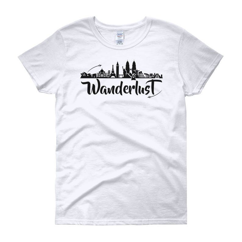May include: White women's t-shirt with a black silhouette of a city skyline and the word "Wanderlust" in black script.