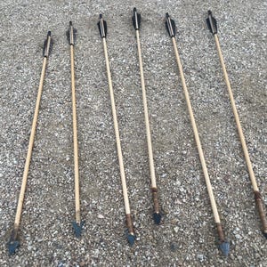 Set of six primitive handcrafted hunting arrows with flint arrowheads