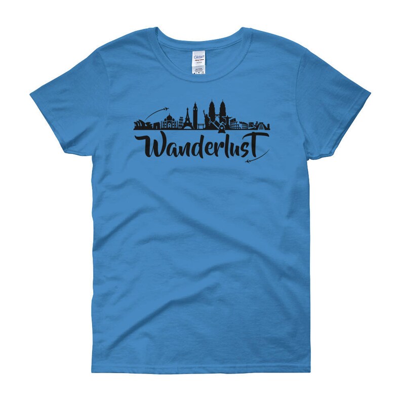 May include: A light blue women's t-shirt with a black silhouette of a city skyline and the word "Wanderlust" in a stylized font.