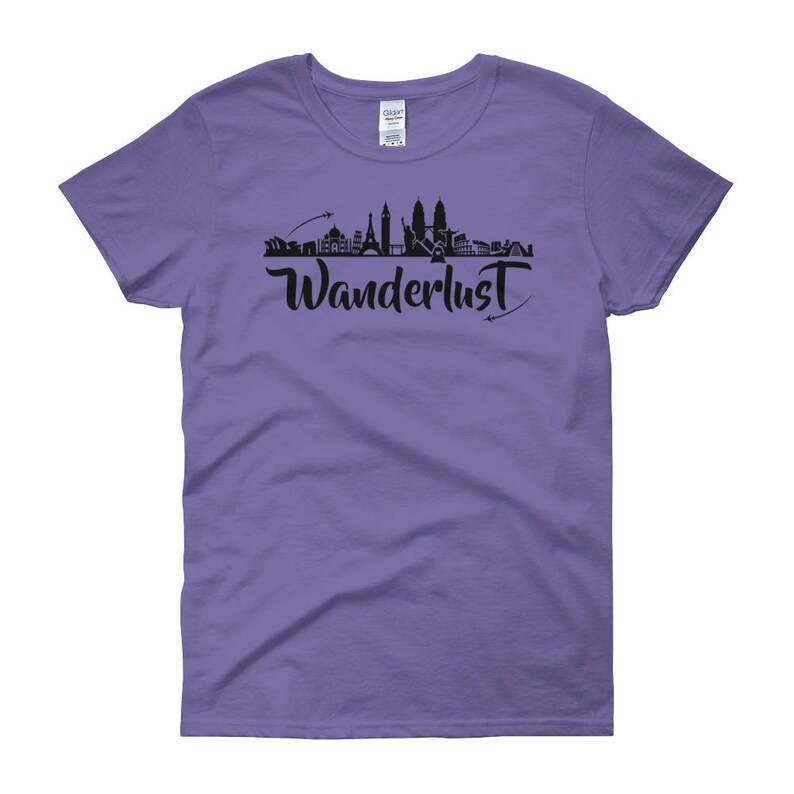 May include: Purple women's t-shirt with a black silhouette of a city skyline and the word "Wanderlust" in black script.