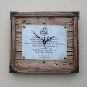 May include: A wooden clock with a quote from Alice in Wonderland. The quote reads: "If I had a world of my own, everything would be nonsense. Nothing would be what it is, because everything would be what it isn't. And contrarywise, what is, it wouldn't be. And what it wouldn't be, it would. You see?"