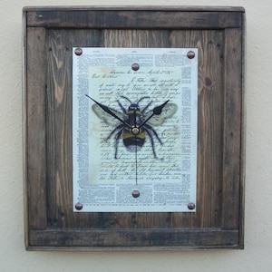 May include: A rustic wooden frame with a vintage newspaper print featuring a bee with clock hands. The print includes the text "Monrai bo Sinn. Aprel Put Brother I take this opportunity of waste ing to you were all will. tist deandels in the word it Side of hill the old lawsui the Fith largers wagong lalake"