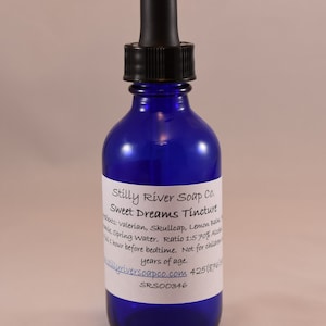 May include: A blue glass bottle with a black dropper top. The bottle is labeled "Stilly River Soap Co. Sweet Dreams Tincture". The label also includes the ingredients, ratio, and instructions for use. The bottle is sitting on a white surface.