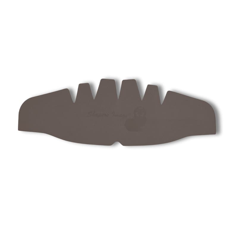 Peut inclure: Une doublure de casque marron avec un motif en relief textur&eacute;. La doublure porte un petit logo qui dit "Shoei Inner Pad" en blanc.