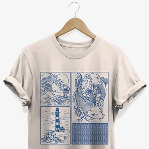 Peut inclure: Un t-shirt beige avec un imprimé graphique bleu de quatre images : une vague, un phare, un poisson-koi et un motif de vagues.