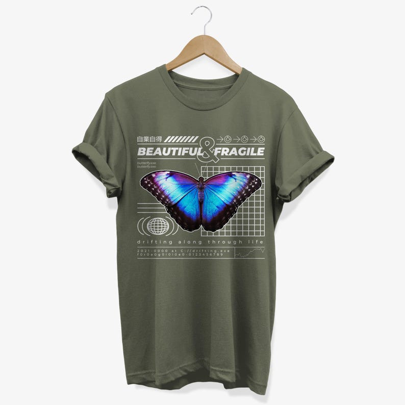 May include: A green t-shirt with a graphic of a blue and purple butterfly on a grid with the text "BEAUTIFUL & FRAGILE" and "drifting along through life".