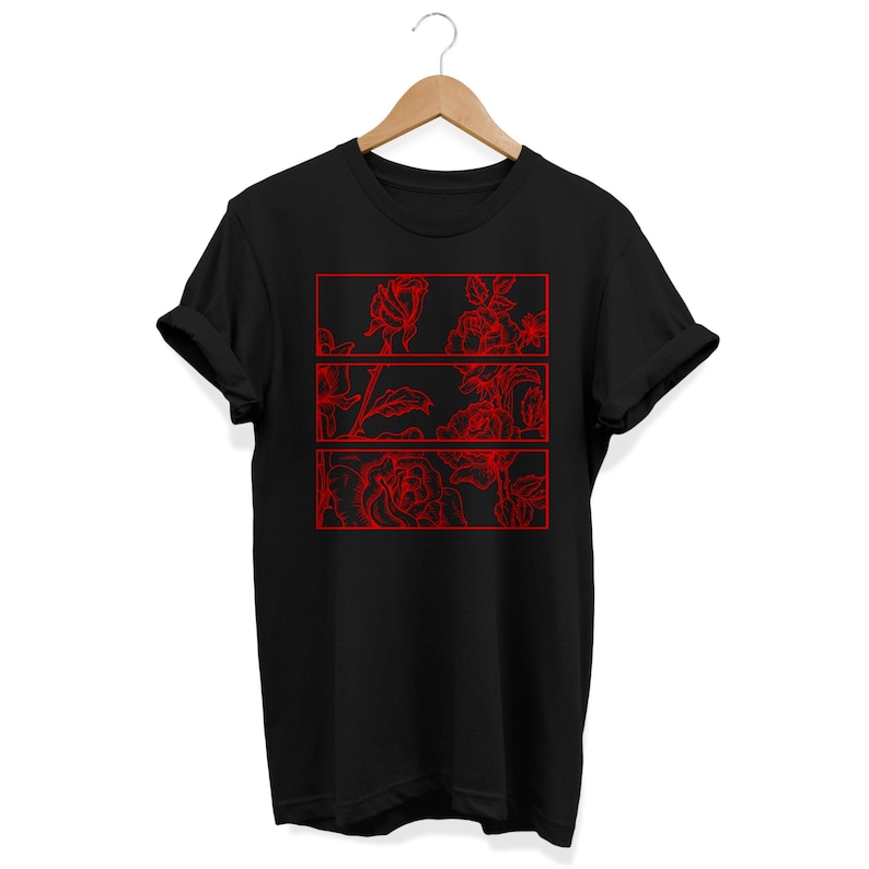 K&ouml;nnte beinhalten: Schwarzes T-Shirt mit rotem Blumendesign. Das Design ist in drei rechteckige Abschnitte unterteilt, die jeweils einen Teil des Rosenmusters zeigen. Das T-Shirt h&auml;ngt an einem Holzb&uuml;gel.