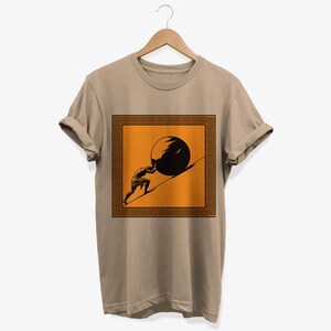 May include: A beige t-shirt with a black silhouette of a person pushing a large stone uphill. The image is framed by a black and orange Greek key border.