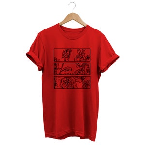 May include: A red t-shirt with a black floral design. The design is divided into three horizontal rectangular panels, each showcasing a different section of a rose illustration. The shirt is displayed on a wooden hanger.
